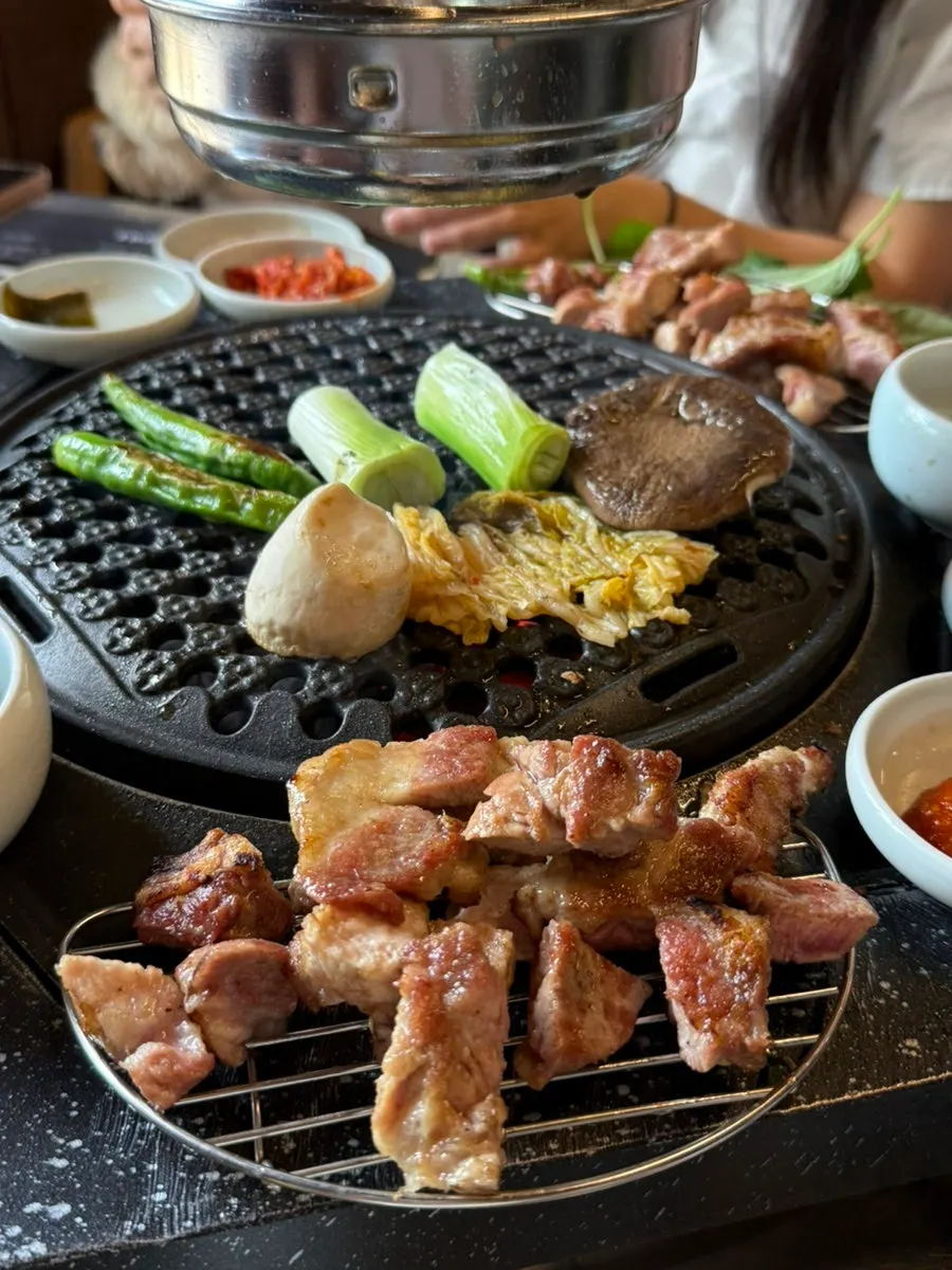 파채를 올려 먹는 구운 돼지고기 한 점
