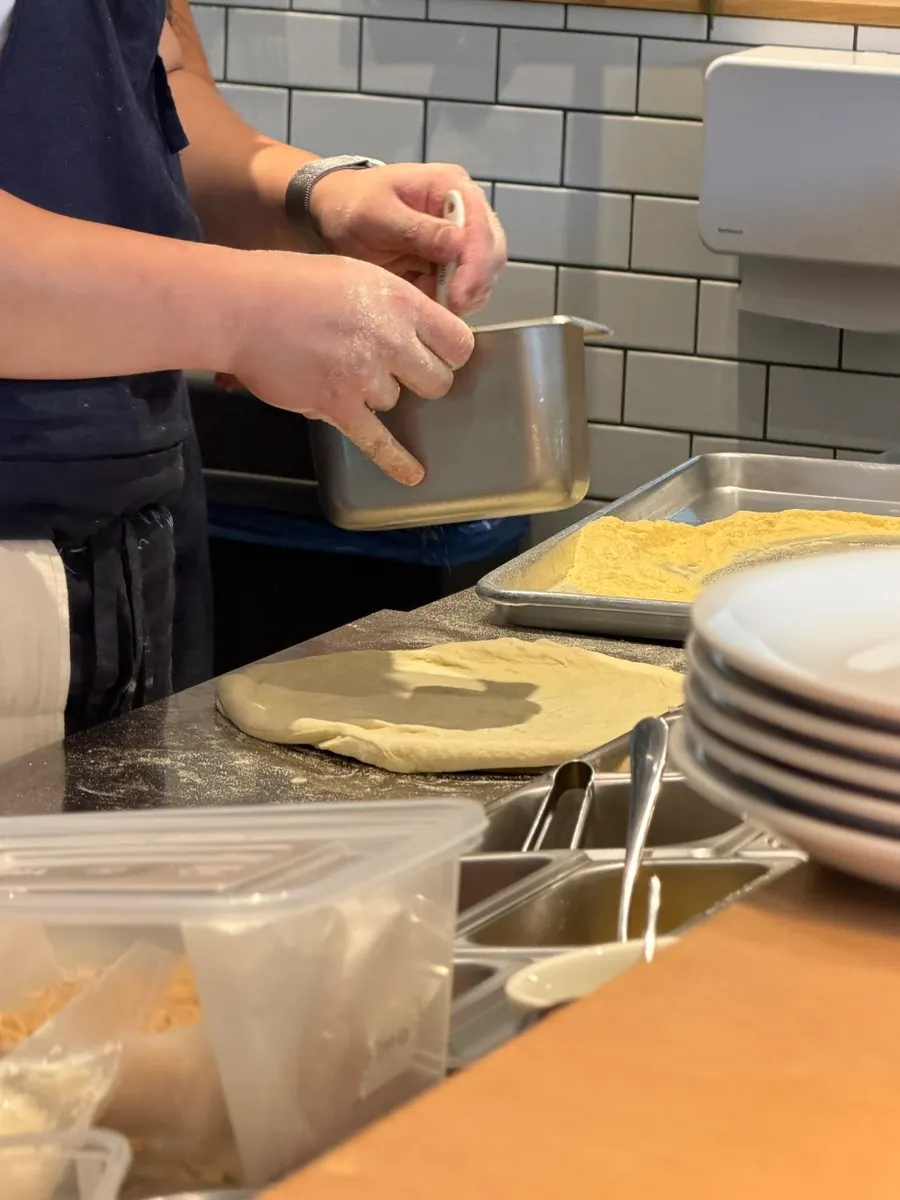 Open kitchen kneading dough right after an order