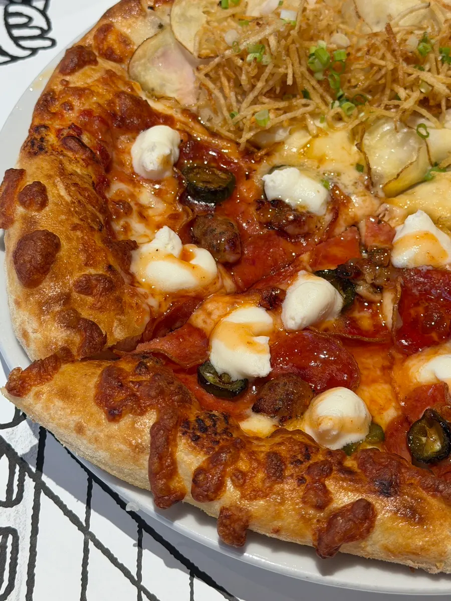 A slice of the fermented-dough pizza lifted up