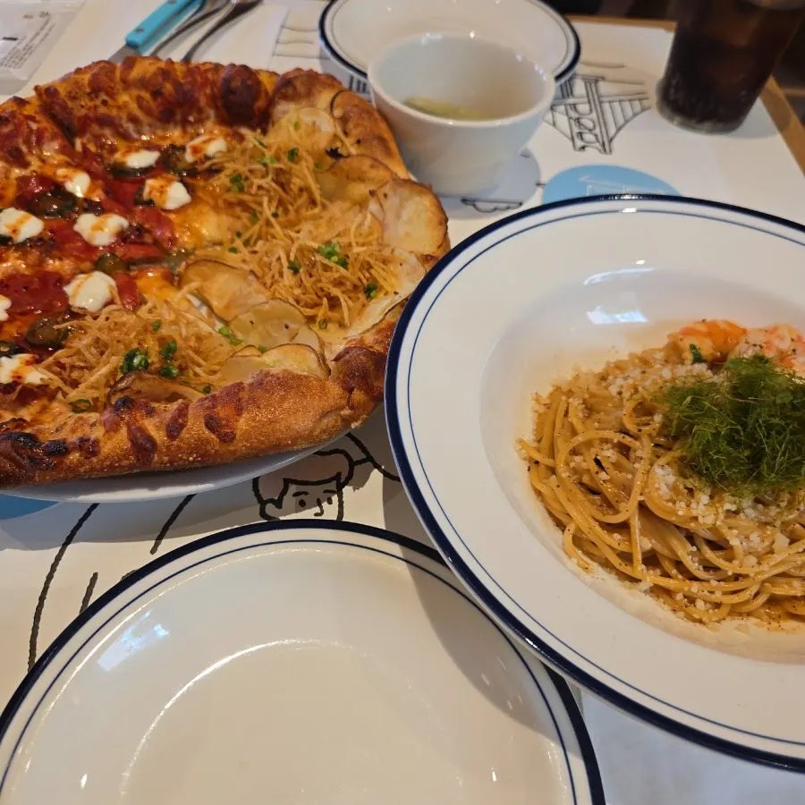 Table with ordered pizza, pasta, and a zero coke