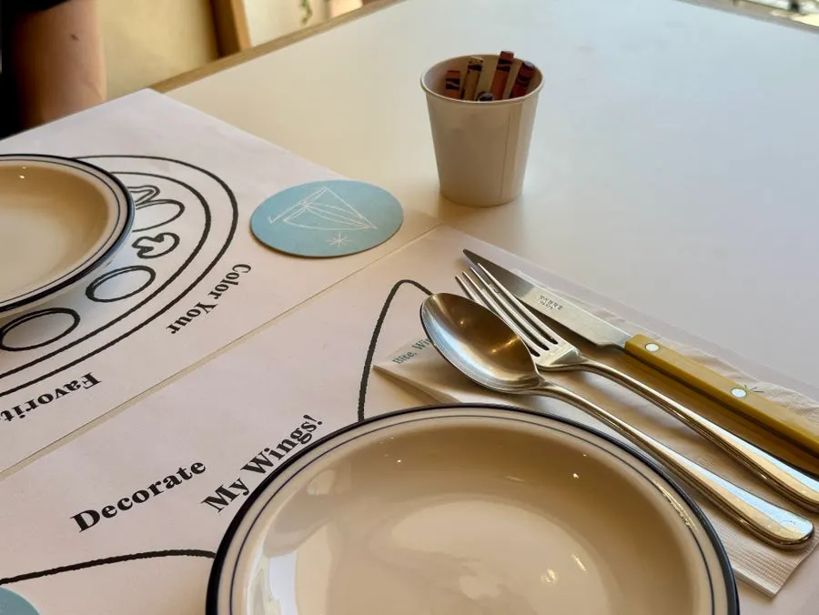 Table setting with plate, sabre knife, and crayons