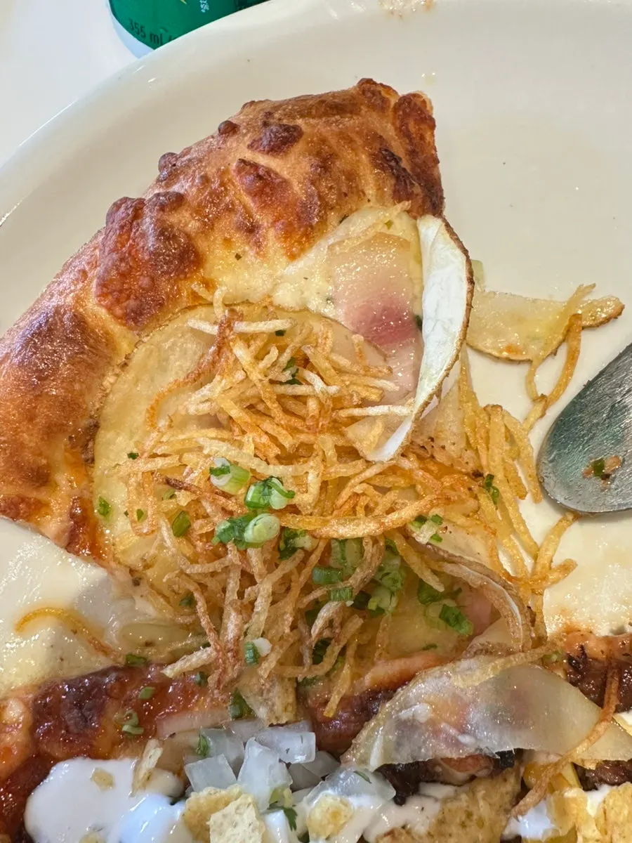 Cross-section of dough with potato topping and white sauce