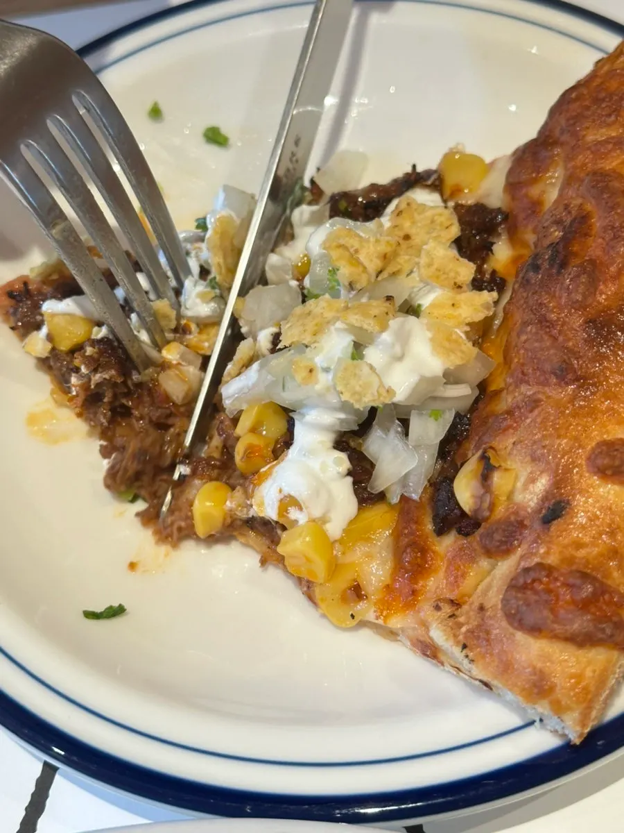A slice of the birria pizza