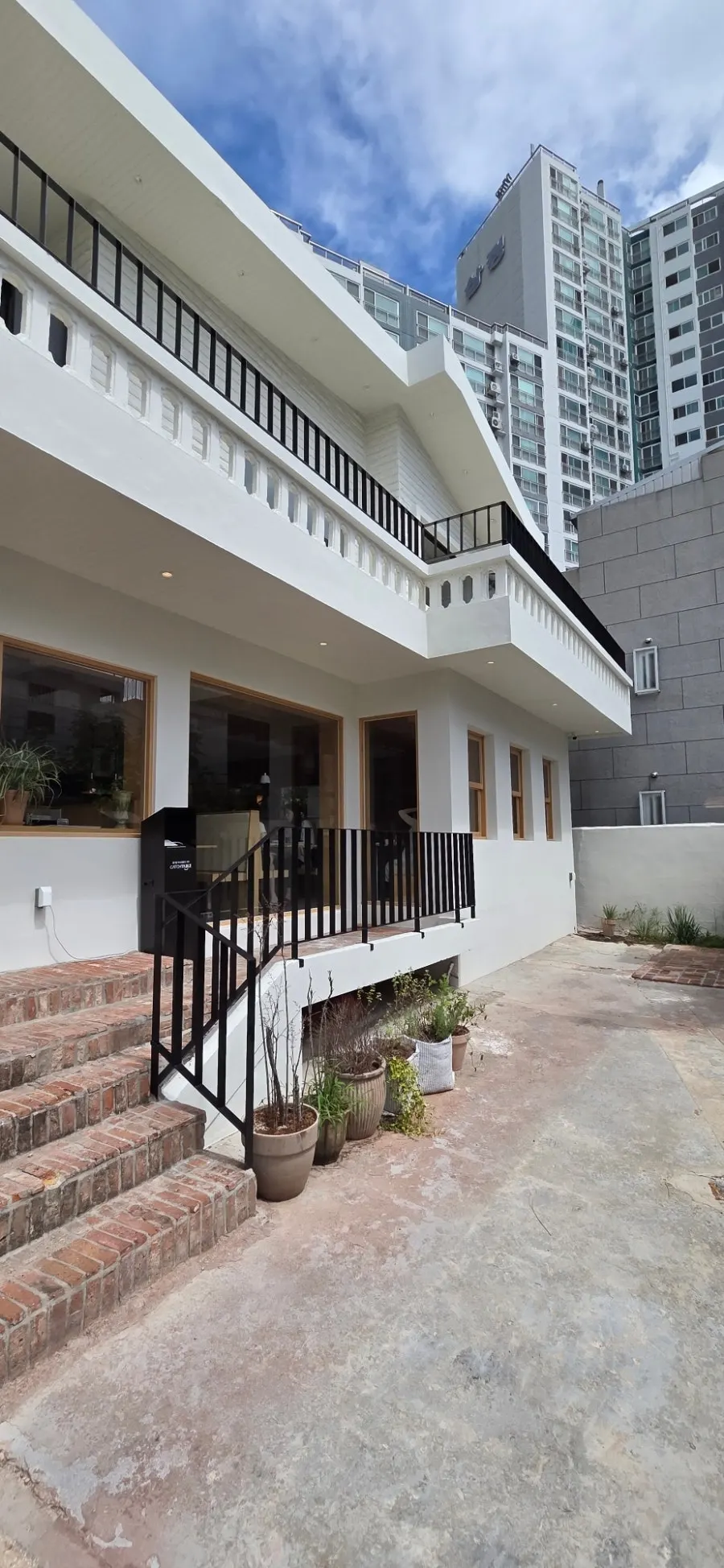 Extra Mile's pure white exterior in the Gwangan-dong alley