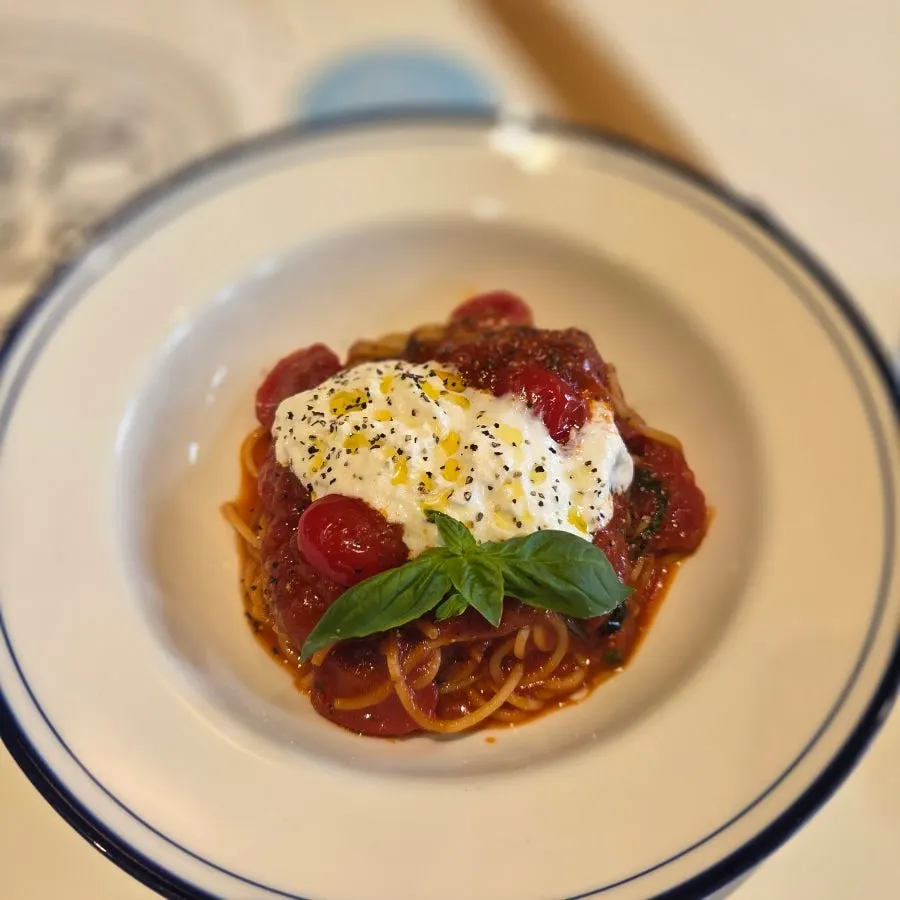 Tomato pasta topped with stracciatella cheese
