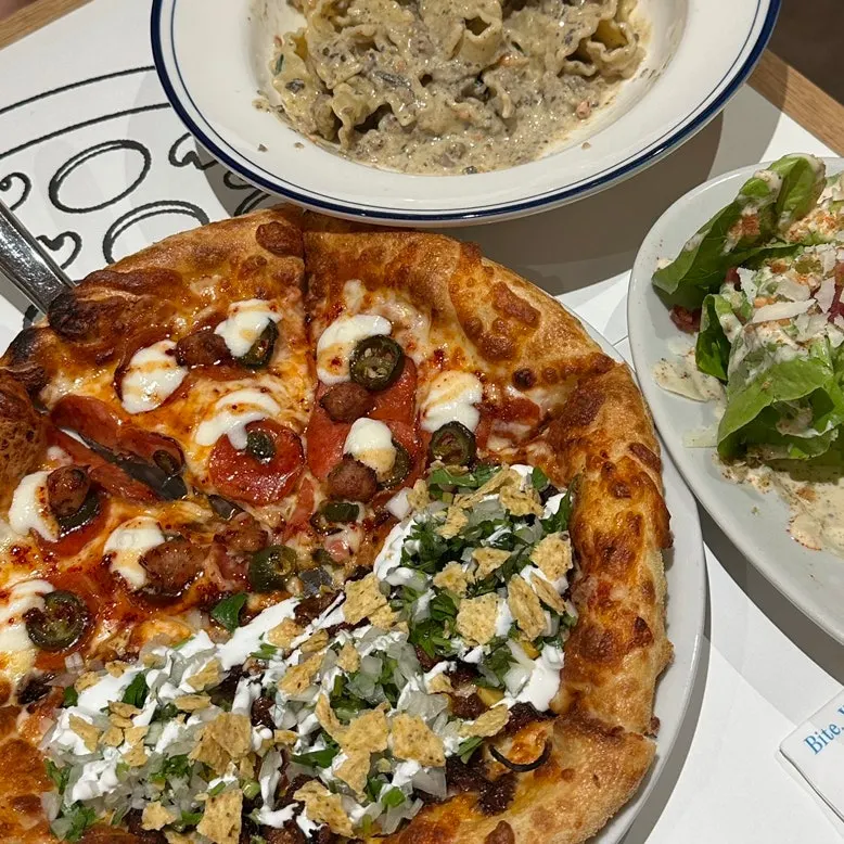 Birria taco pizza topped with beef and cilantro salsa