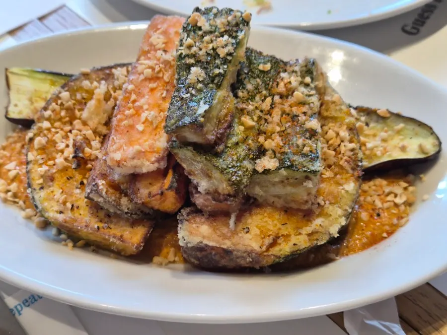 Grilled vegetable side served over romesco sauce