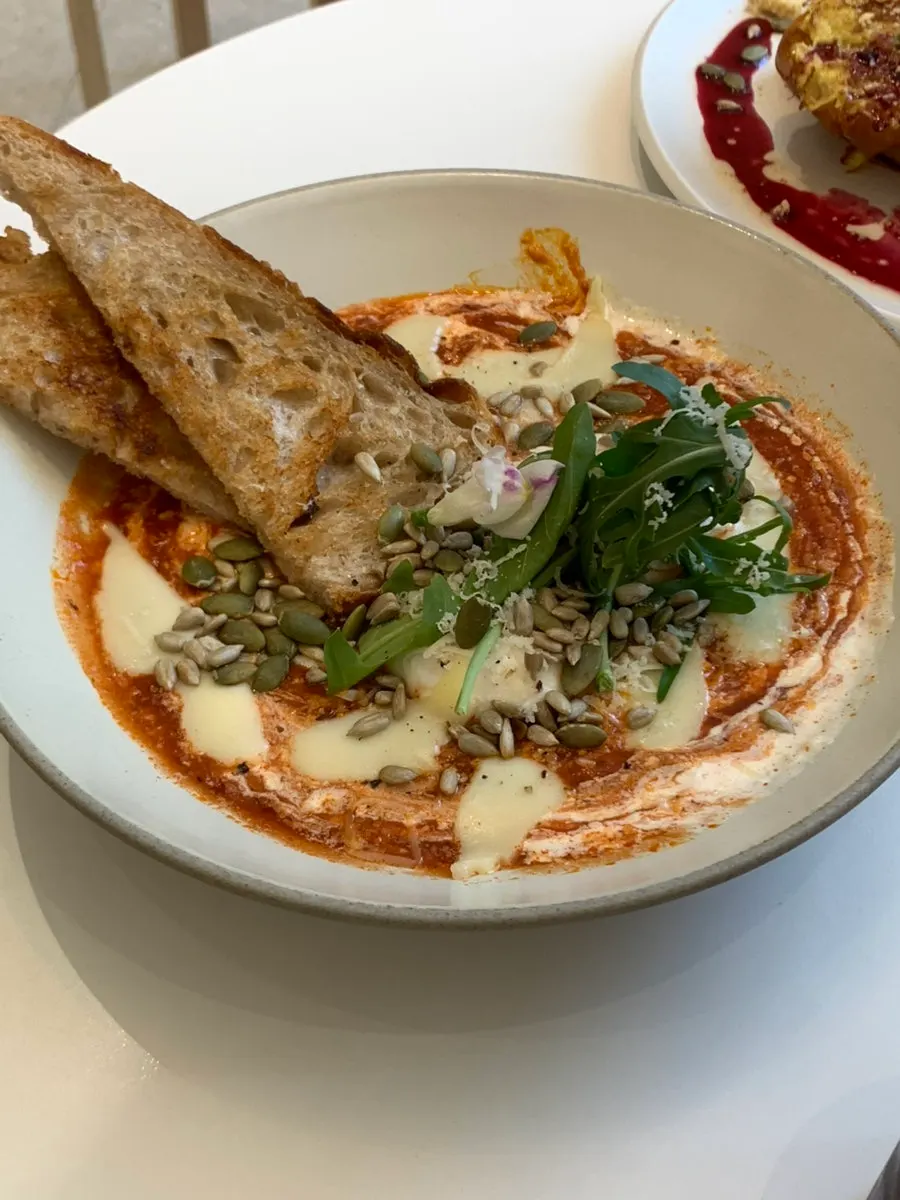 Egg in Hell shakshuka topped with poached egg and sourdough