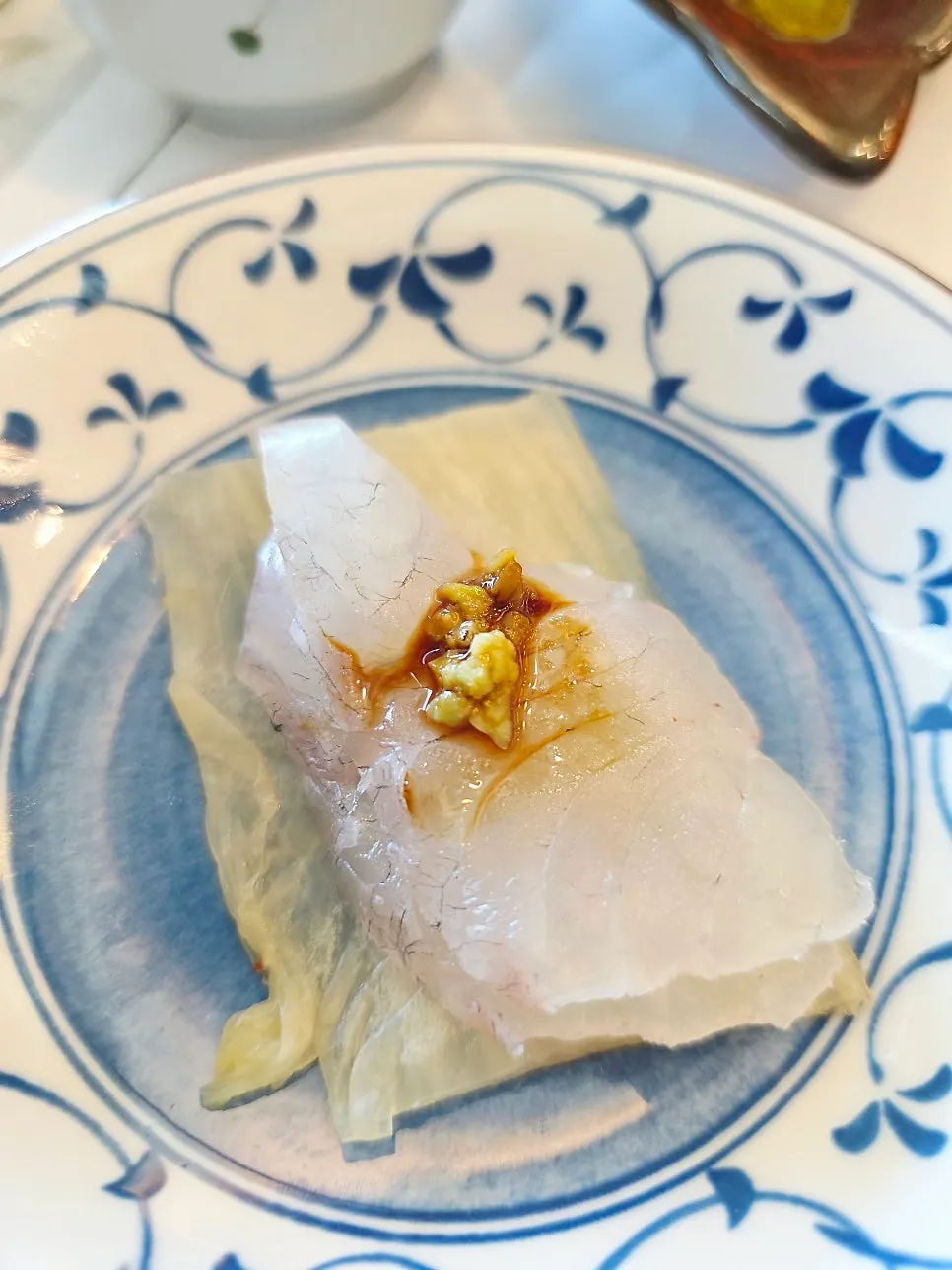 A bite of sashimi eaten with white kimchi
