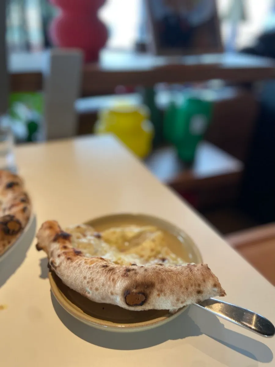 A slice of gorgonzola pizza lifted up
