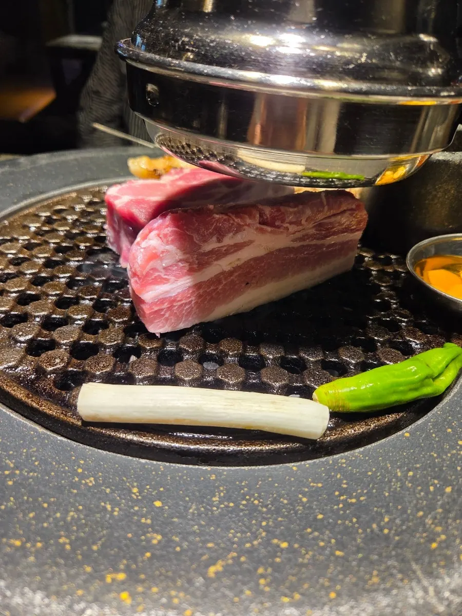 Thick pork neck cooking on the grill plate
