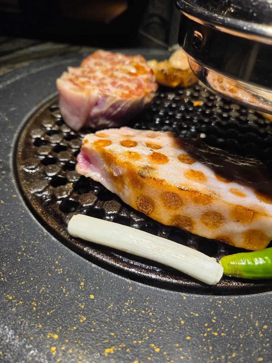 Pork belly and pork neck grilling to a golden brown