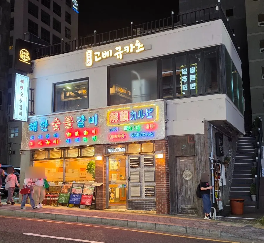 네온사인 조명이 켜진 해안숯불갈비 광안리 본점 외관