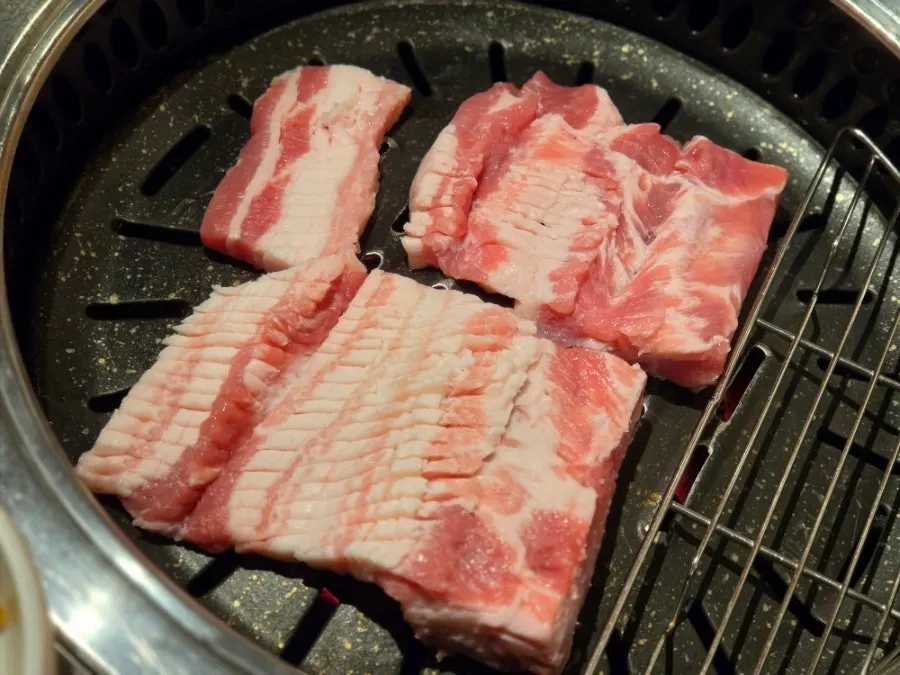 숯불 위에서 구워지는 두툼한 돼지갈비