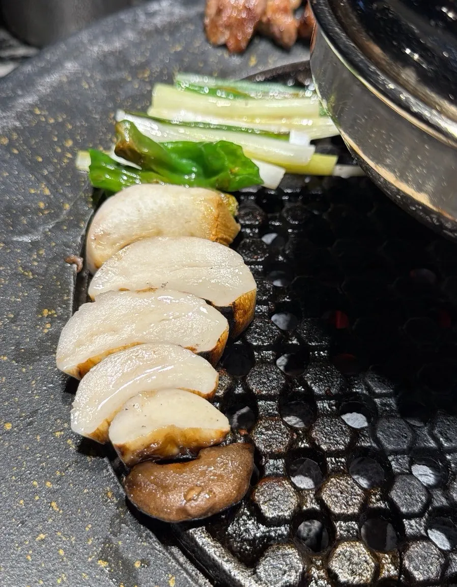Cooked meat placed around the outer edge of the grill