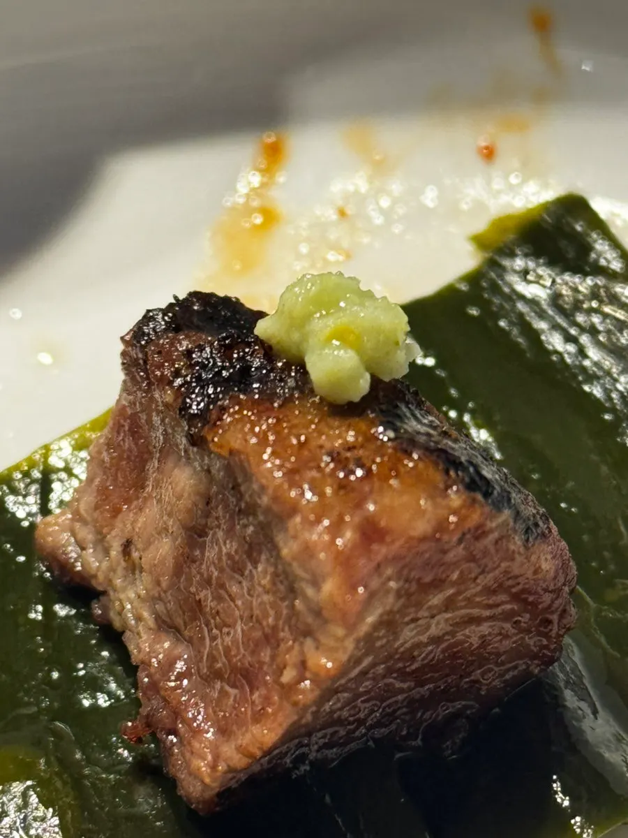 A piece of pork belly topped with wasabi