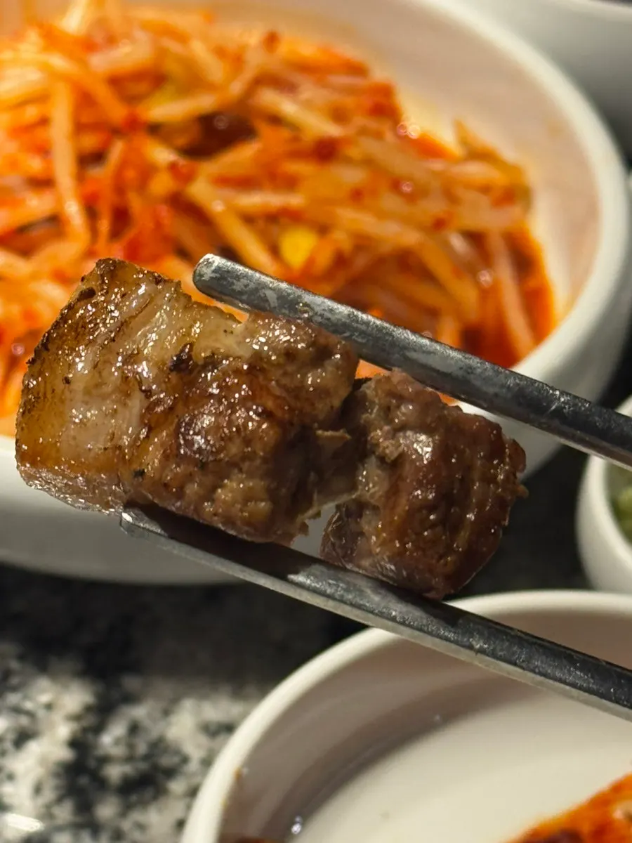 Meat paired with white kimchi and green onion