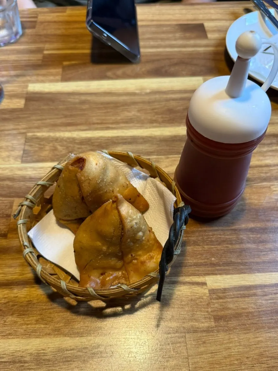 Two samosas served with ketchup