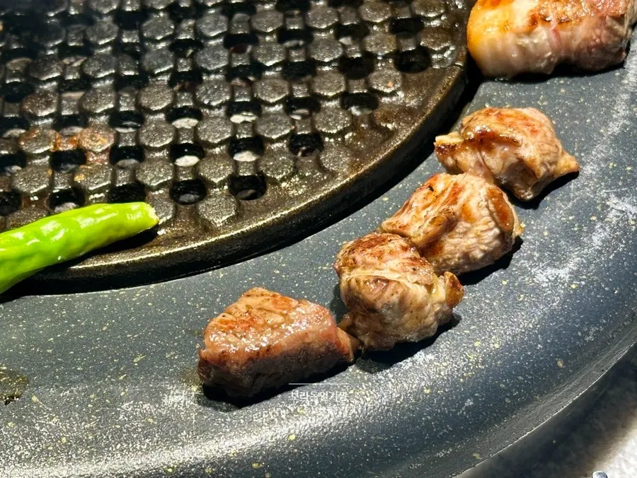 불판 테두리에 올려둔 다 구운 돼지고기