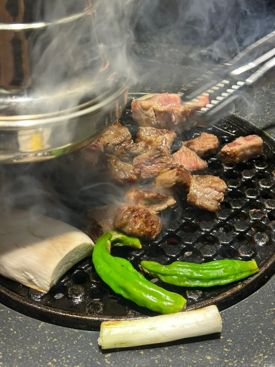 Meat being cut into bite-sized pieces while grilling