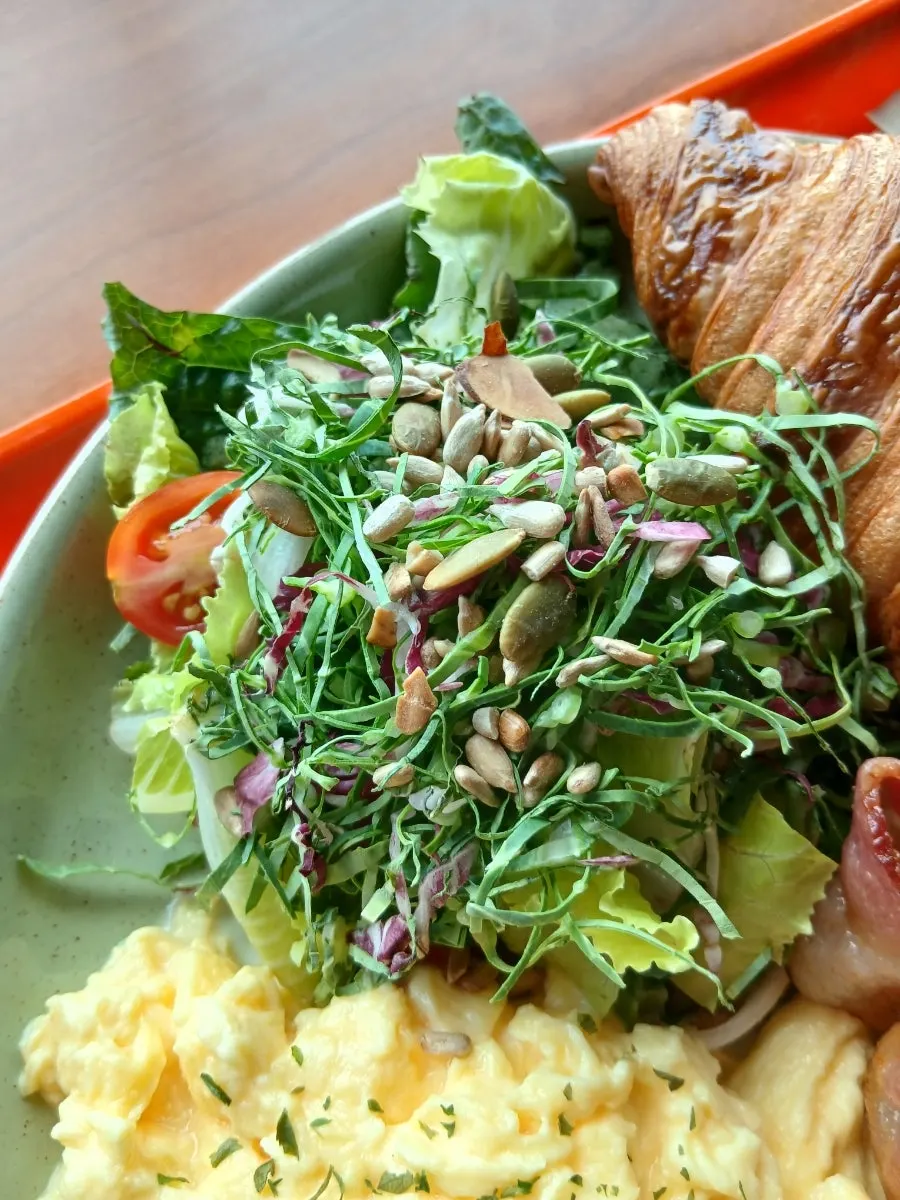 Brunch topped with half an avocado and scrambled eggs
