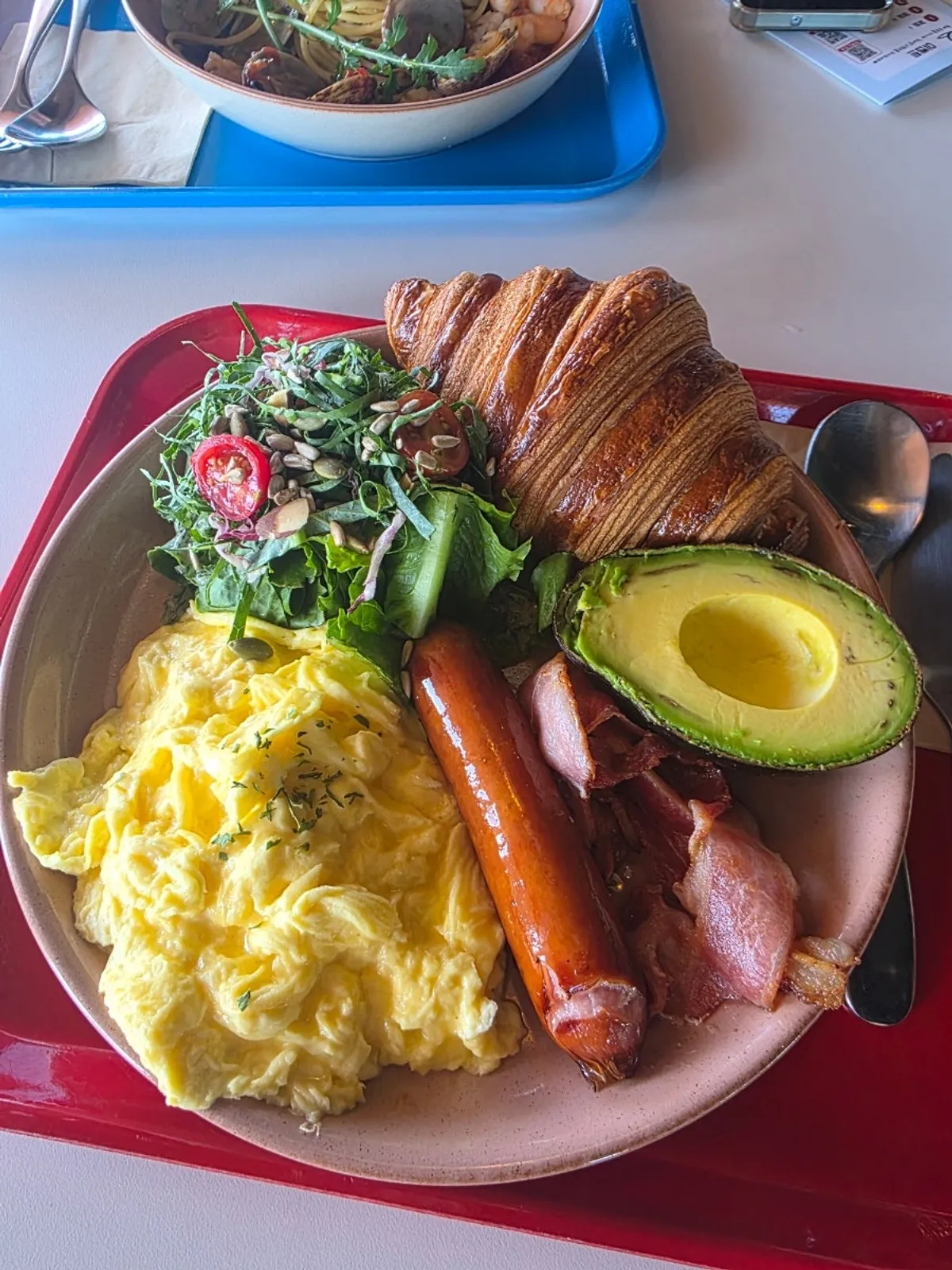 Big Brekkie and shrimp oil pasta set on a window table with ocean view