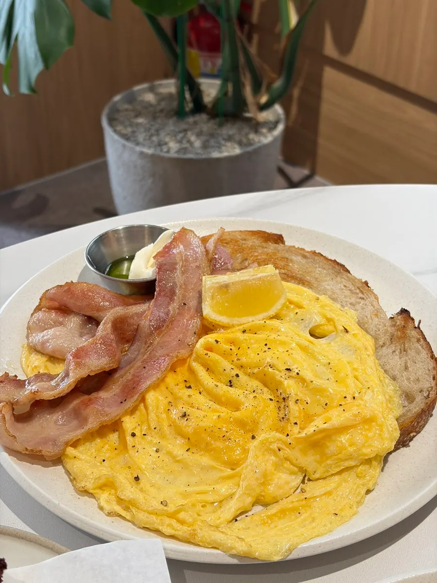 Toast topped with scrambled egg and bacon