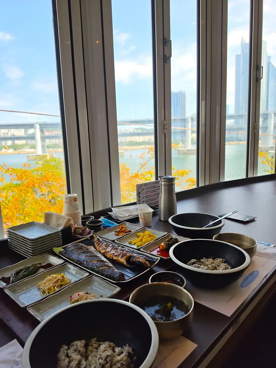 Wood-fired grilled fish spread with a Gwangan Bridge view