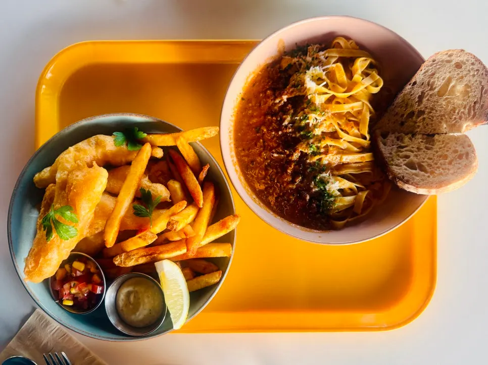 Fish and chips and Bolognese pasta set on the table