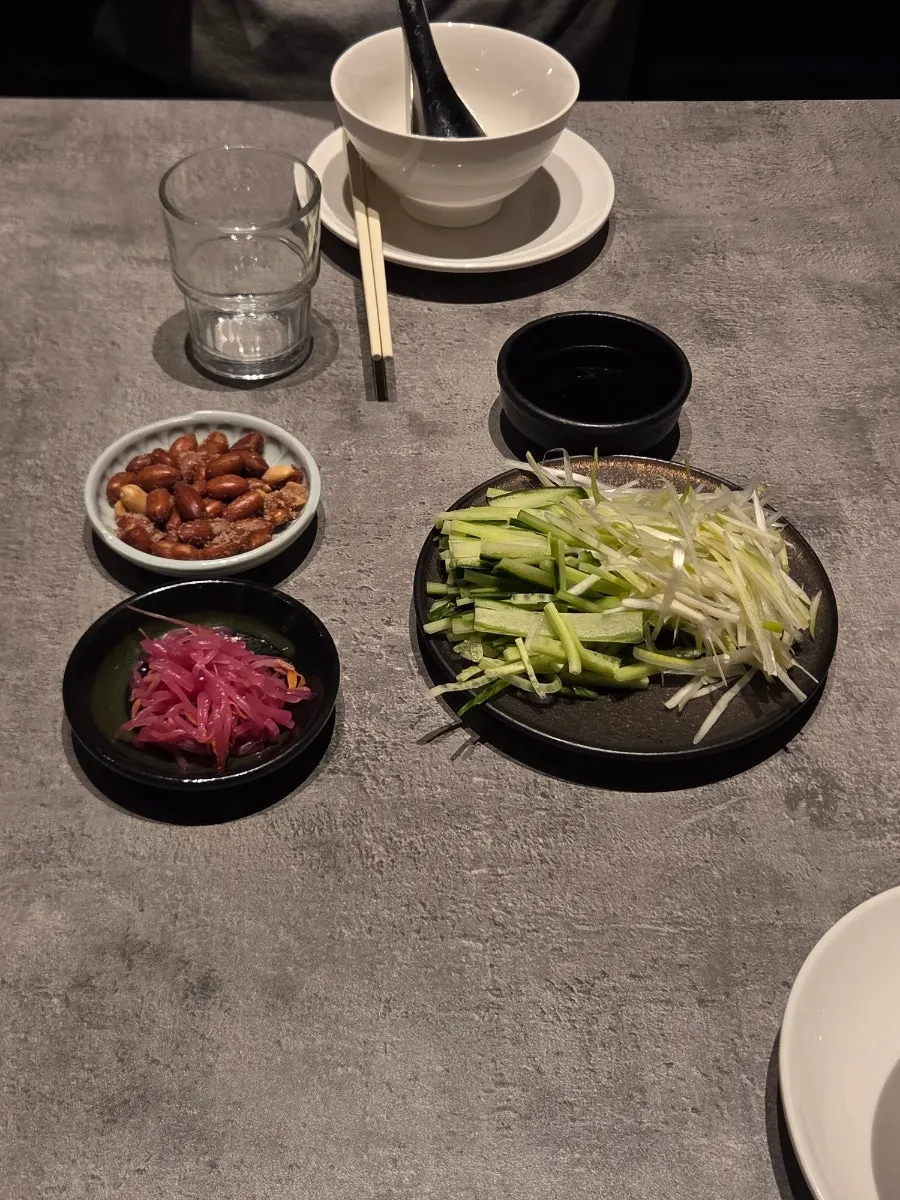 Julienned cucumber, scallion, pickled mustard greens and peanuts as basic side dishes