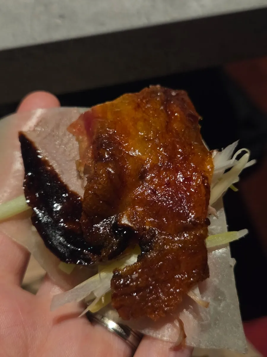 A bite of Peking duck wrapped in thin pancake