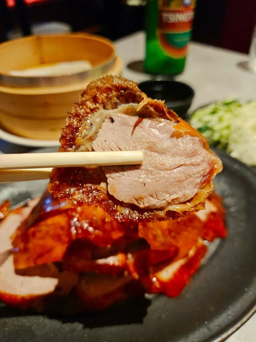 Wrapping Peking duck and vegetables in a wheat pancake