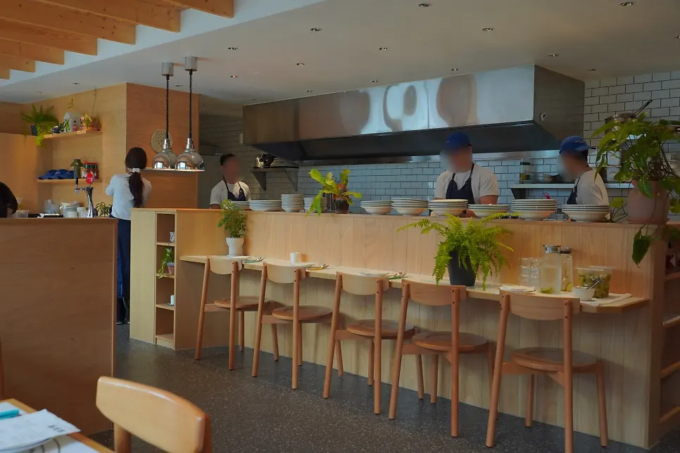 Dining space with green plants and an open kitchen