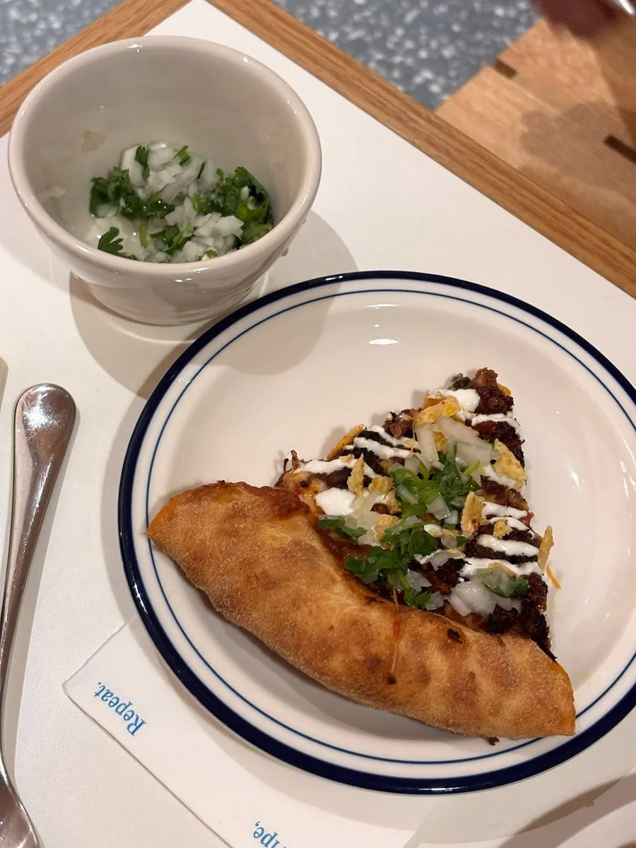 A slice of birria taco pizza