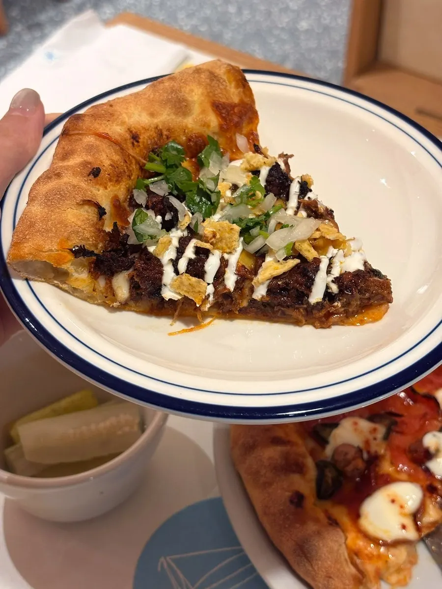 Taco pizza topped with cilantro served on the side