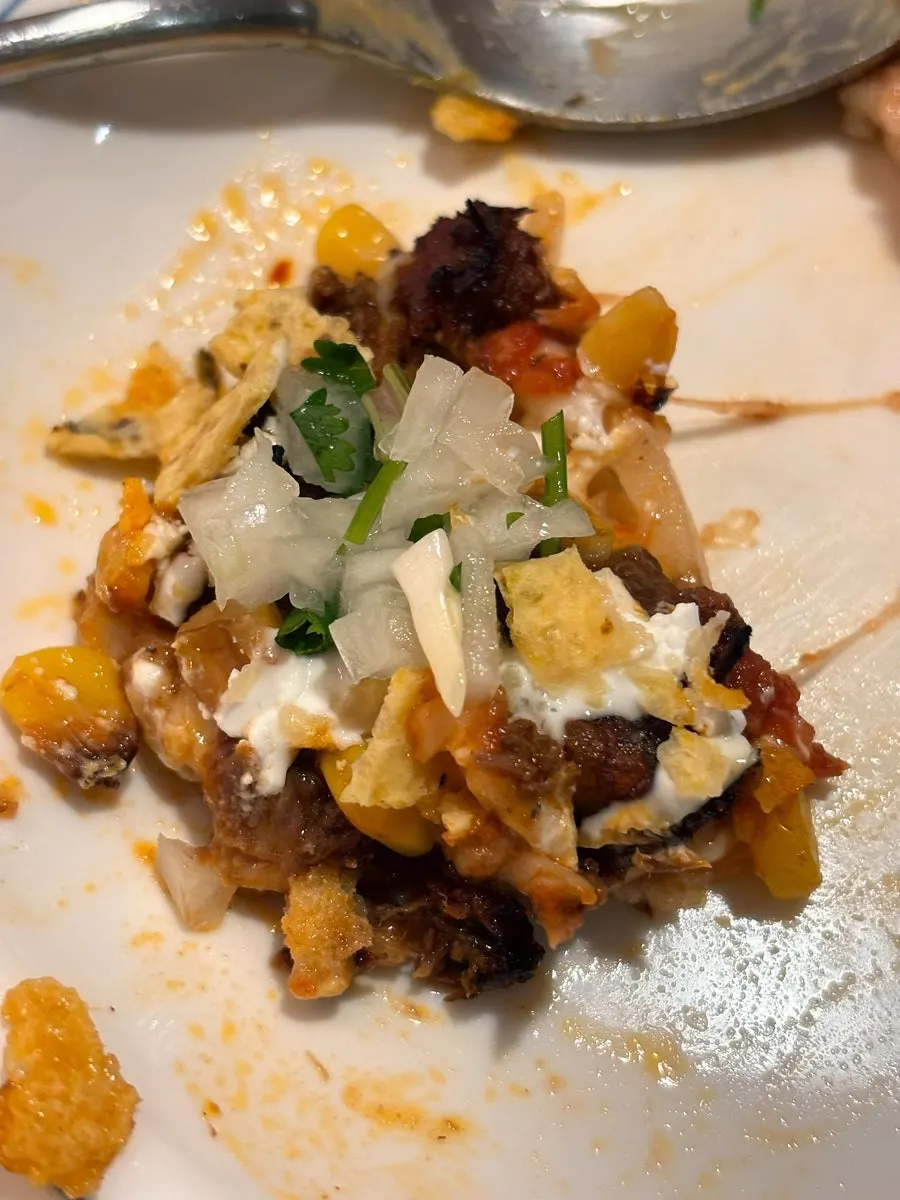Birria taco pizza topped with cilantro and onion