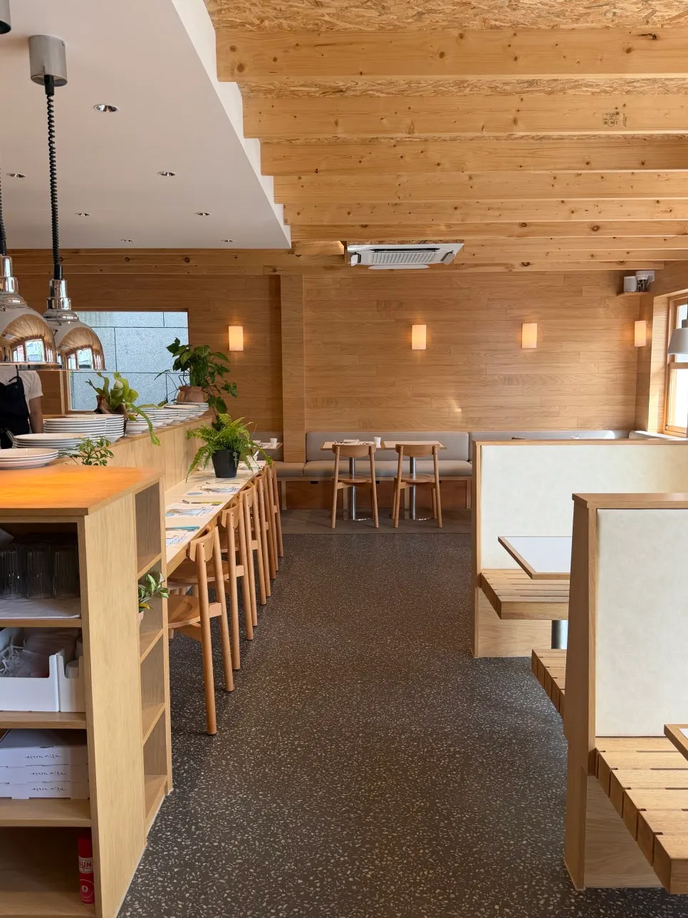 Extra Mile's first-floor entrance with a white exterior and wood window frames