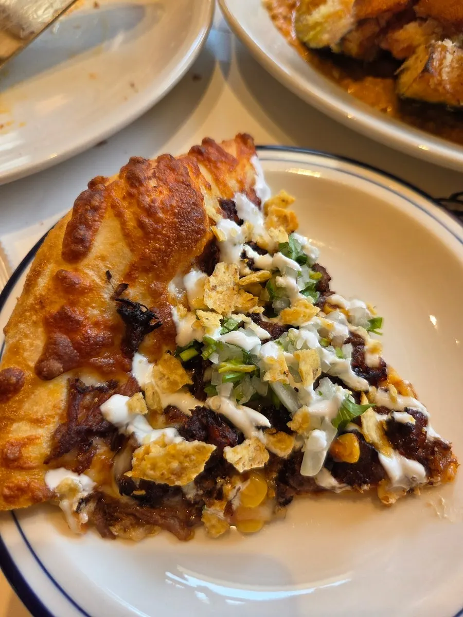 Vertical photo of the birria pizza topped with taco