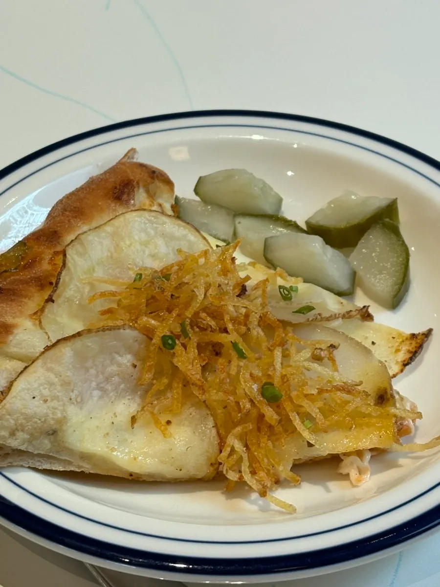 Potato pizza topped with sliced potato and shredded fried potato