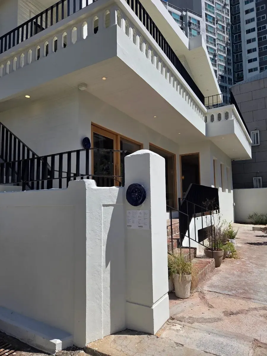 Extra Mile's stark white exterior in a converted house