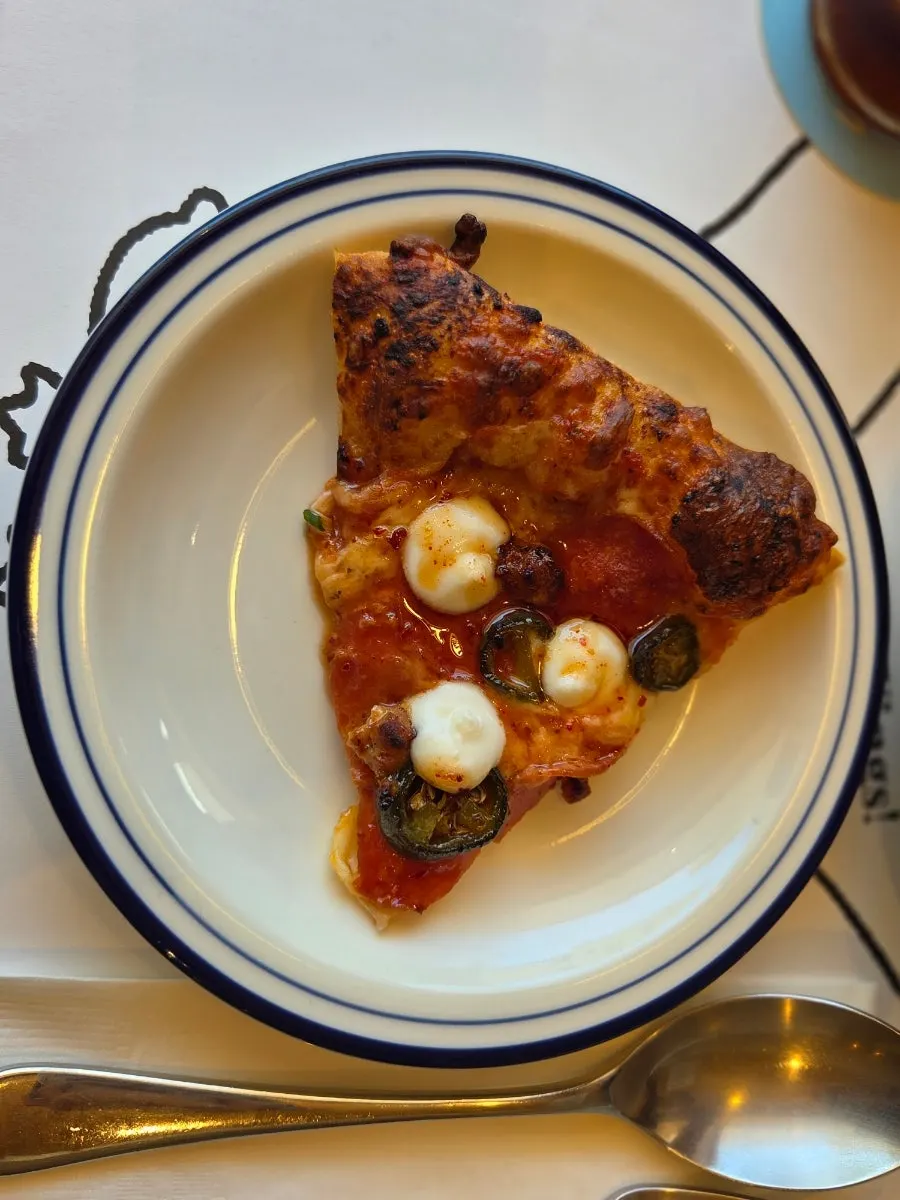 Slice of potato pizza topped with fried julienned potato