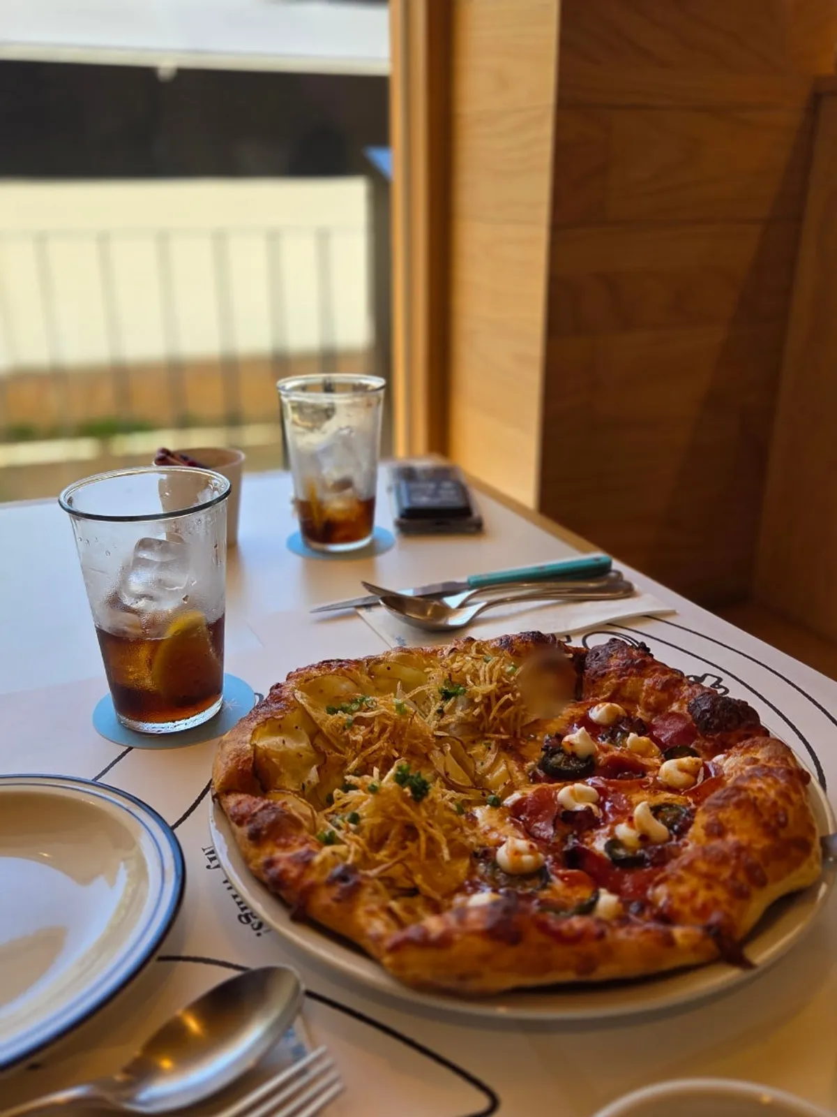 Table set for two with half-and-half pizza and pasta