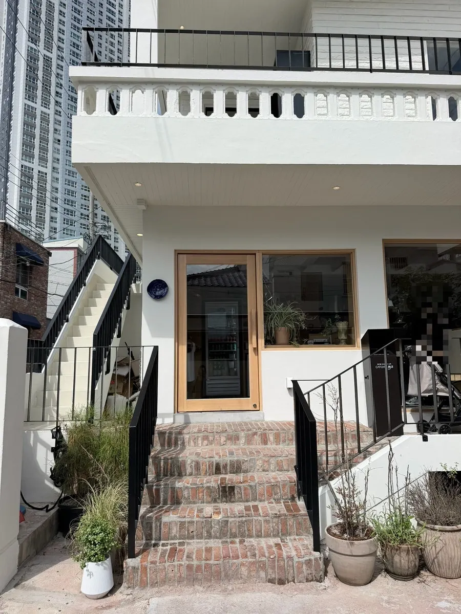 Exterior of Extra Mile's alley building with a blue plate hanging on it