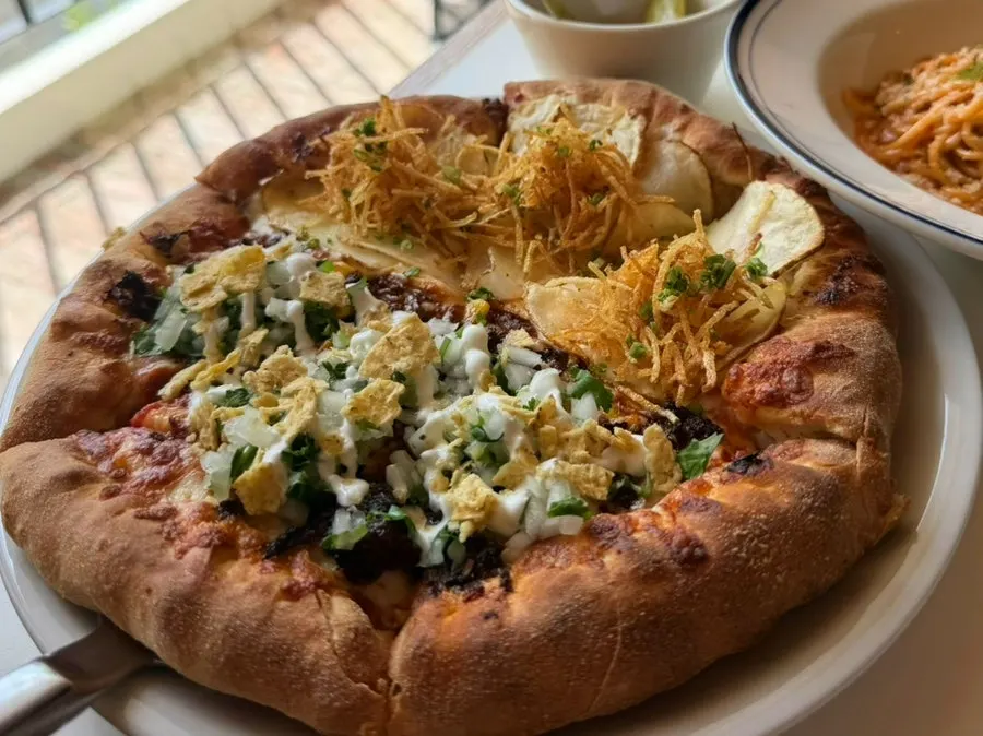 Table spread of the birria taco and potato half-and-half pizza
