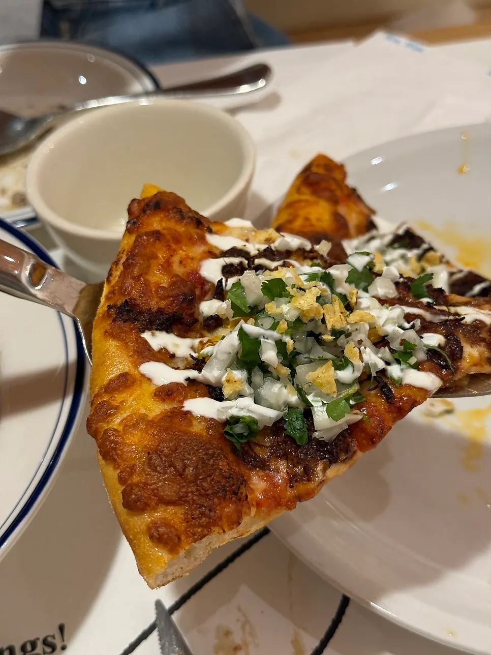 Birria taco pizza topped with meat and cilantro