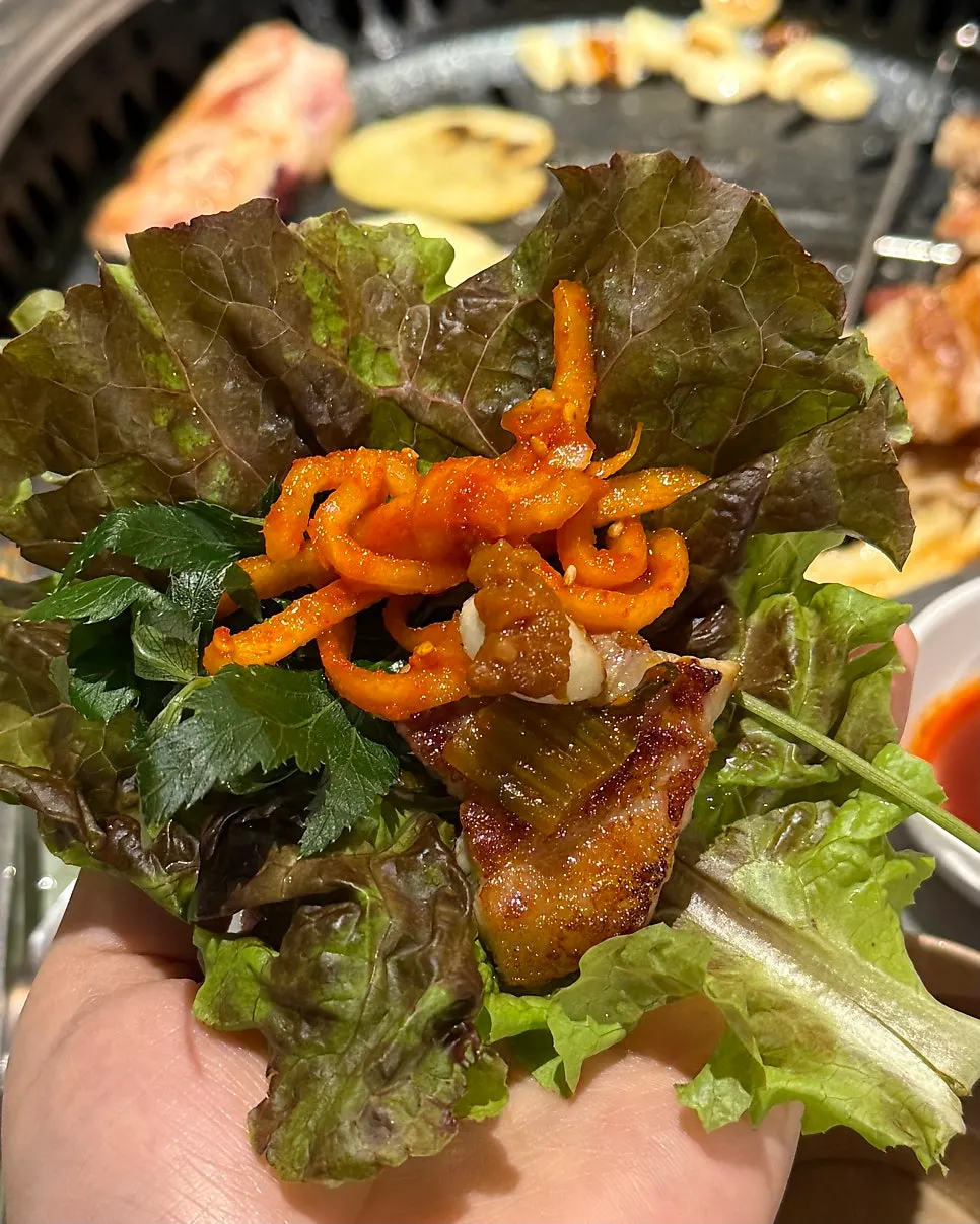 A wrap with angelica leaf, radish salad, and mustard leaf pickle