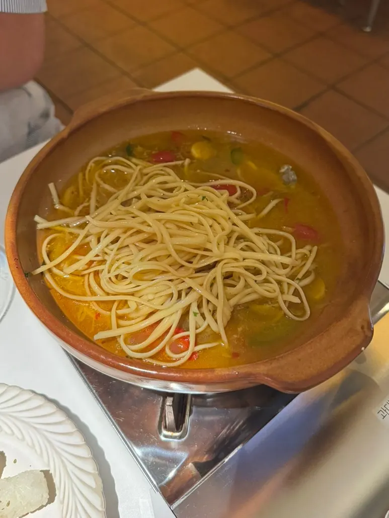 Pasta noodles added to the clam wine broth