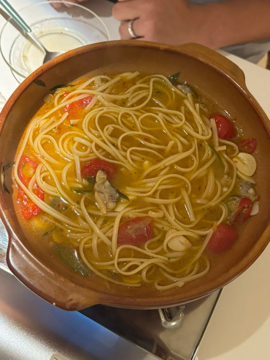 A bowl of thick pasta noodles soaked in broth