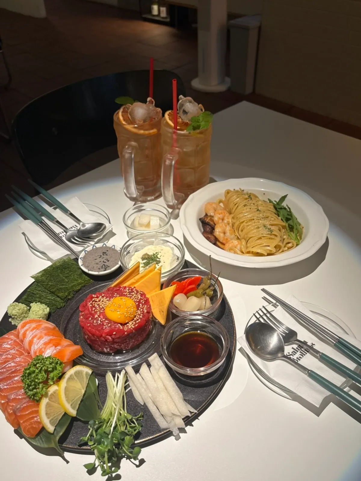 Salmon, beef tartare, and aglio e olio food combo spread