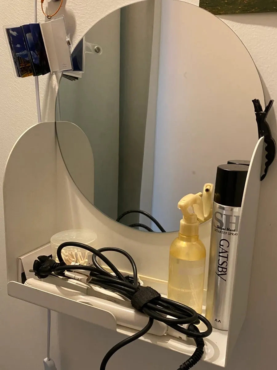 Curling iron, hairspray and cotton swabs set up in front of the restroom